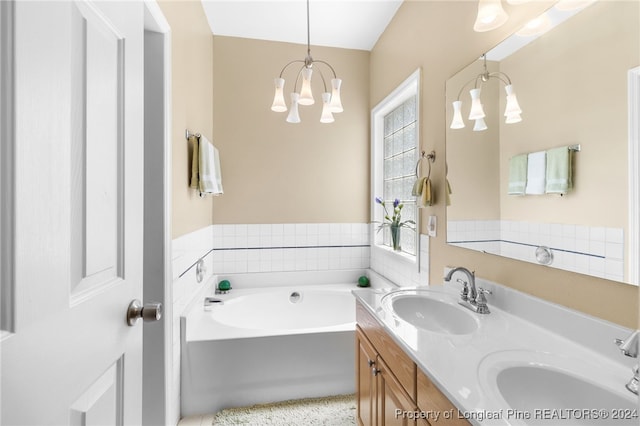 bathroom with vanity, a bathing tub, and a notable chandelier