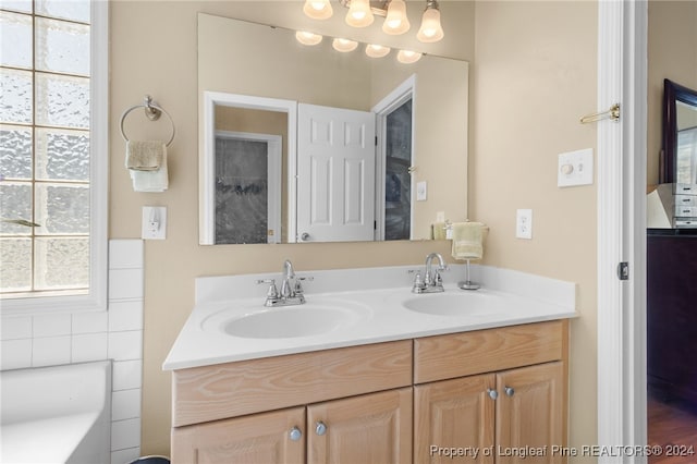 bathroom with tile walls, a bathtub, and vanity