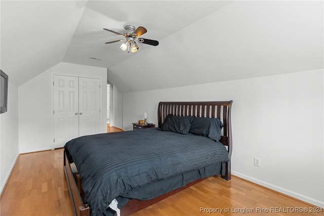 bedroom with lofted ceiling, light hardwood / wood-style flooring, ceiling fan, and a closet