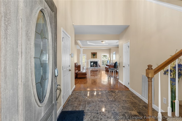 foyer entrance with crown molding and dark hardwood / wood-style flooring