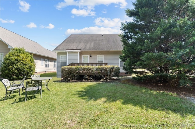 rear view of property with a yard and a deck