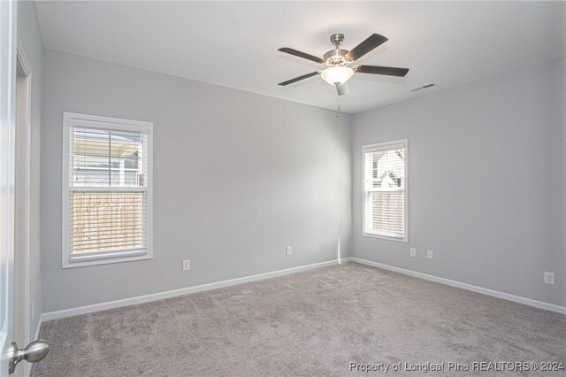 carpeted spare room featuring ceiling fan