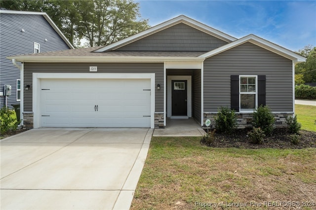 view of front of property featuring a garage and a front lawn