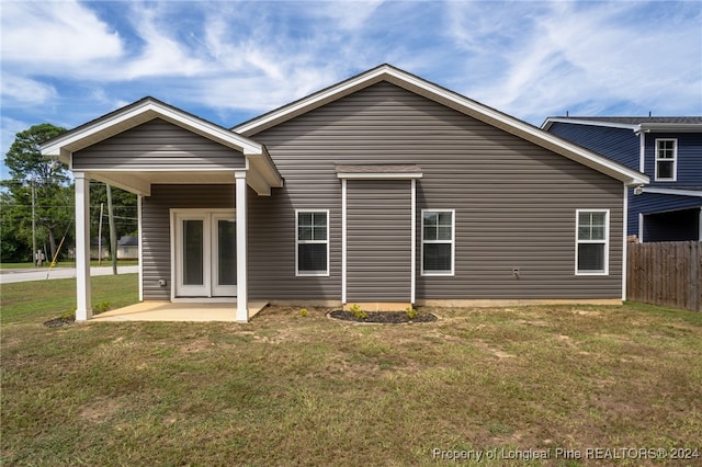 rear view of property featuring a patio area and a yard