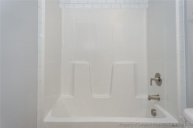 bathroom with toilet and washtub / shower combination