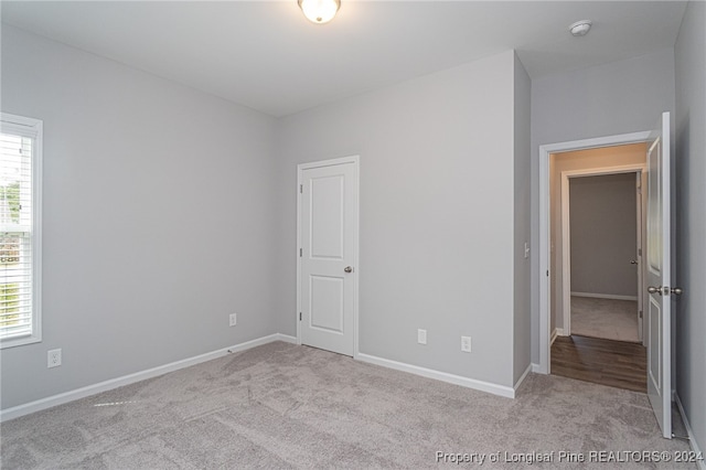 unfurnished bedroom featuring light carpet