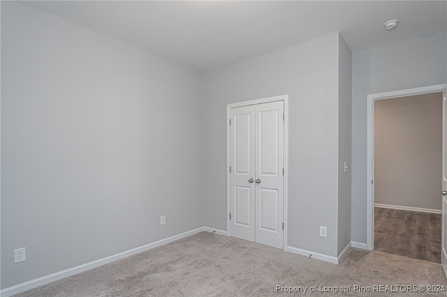 unfurnished bedroom with a closet and carpet flooring