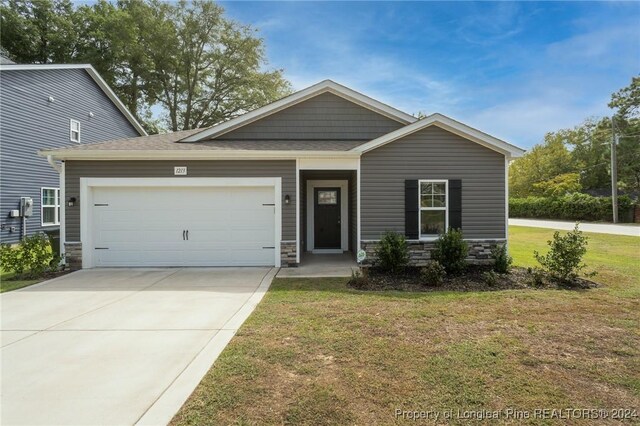 view of front of home with a garage and a front lawn