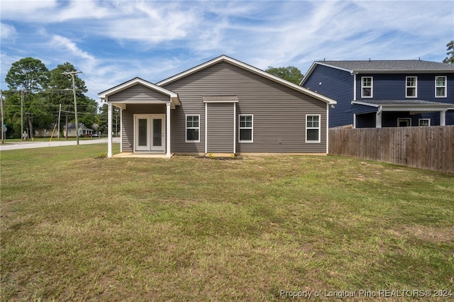 rear view of house featuring a yard