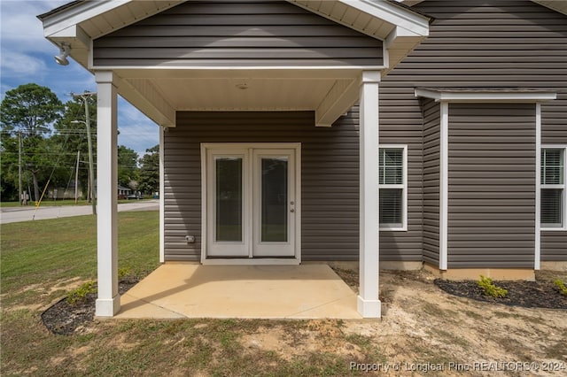 view of exterior entry with a lawn