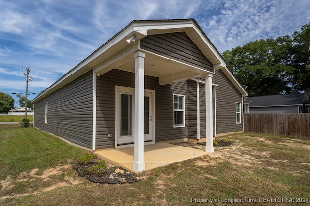 rear view of property with a lawn and a patio