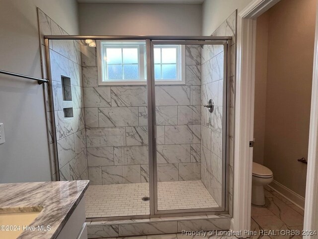 bathroom featuring vanity, toilet, and walk in shower