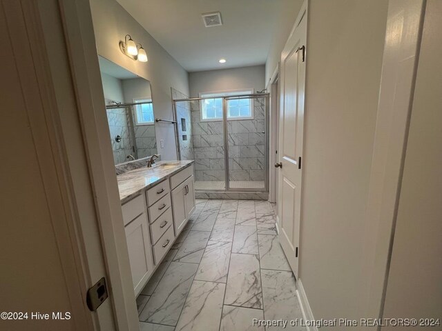 bathroom featuring vanity and a shower with door