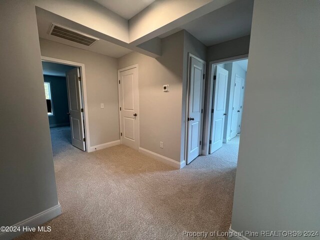 hallway featuring light colored carpet