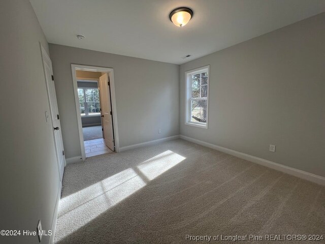 carpeted spare room featuring plenty of natural light