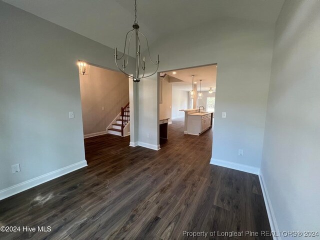 unfurnished dining area with dark hardwood / wood-style floors and an inviting chandelier