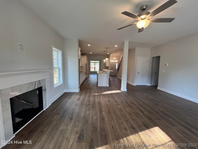 unfurnished living room with a premium fireplace, ceiling fan, and dark hardwood / wood-style floors