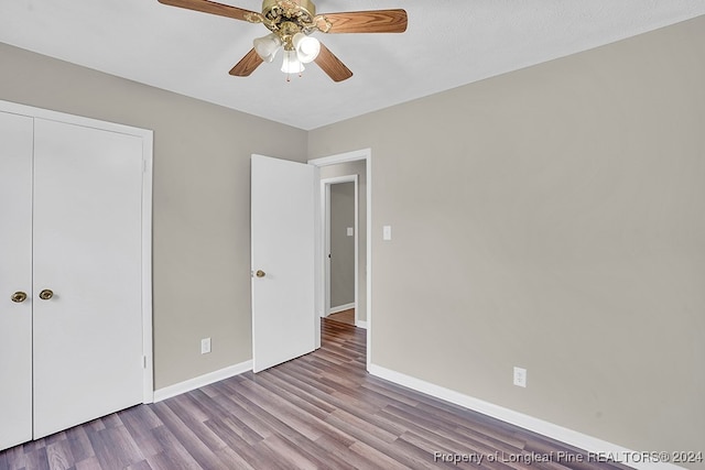 unfurnished bedroom featuring light hardwood / wood-style flooring, a closet, ceiling fan, and a textured ceiling