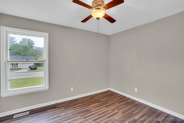 spare room featuring a healthy amount of sunlight, ceiling fan, hardwood / wood-style floors, and a textured ceiling