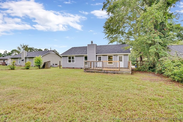 back of property featuring a wooden deck and a yard