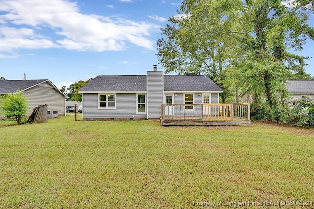 rear view of property with a lawn and a wooden deck