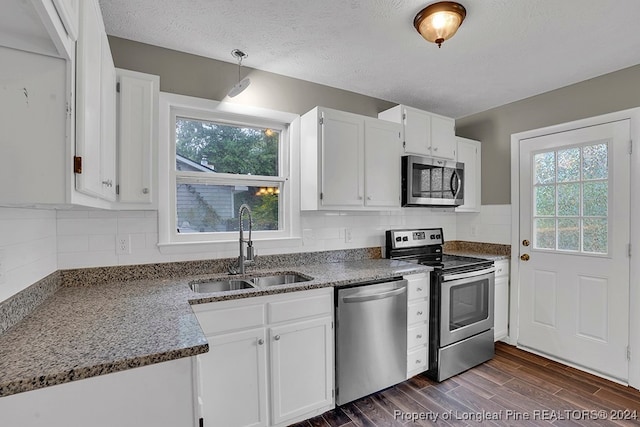 kitchen featuring white cabinetry, appliances with stainless steel finishes, dark wood-type flooring, and sink