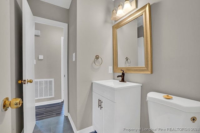 bathroom with tile patterned flooring, vanity, and toilet