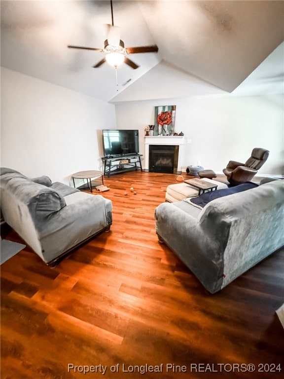 living room with ceiling fan, vaulted ceiling, and hardwood / wood-style floors