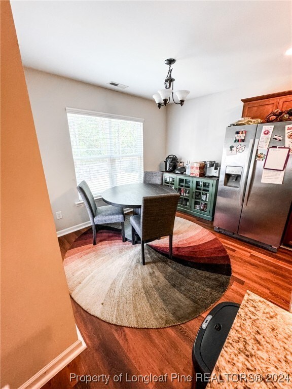 dining space featuring hardwood / wood-style flooring and a chandelier