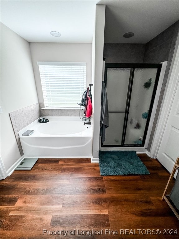 bathroom featuring plus walk in shower and hardwood / wood-style floors