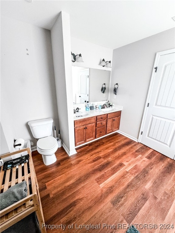 bathroom featuring wood-type flooring, vanity, and toilet