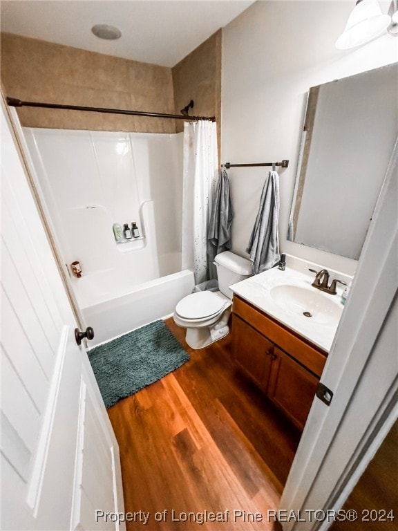 full bathroom with vanity, shower / tub combo, toilet, and hardwood / wood-style flooring