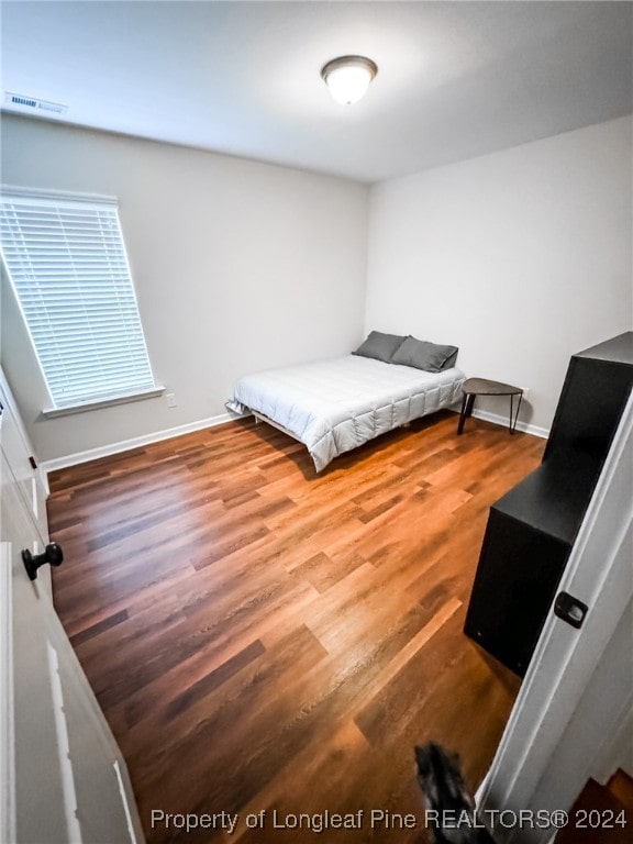 bedroom with hardwood / wood-style flooring