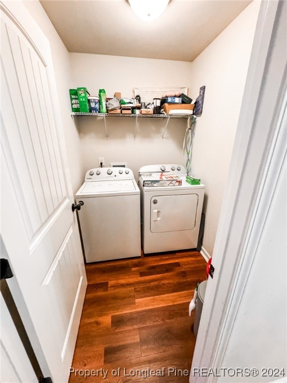 clothes washing area with separate washer and dryer and dark wood-type flooring