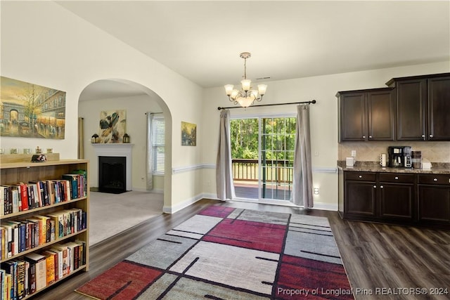 5166 Aberdeen Rd, Raeford, NC 28376 - doorway with a chandelier, arched walkways, a fireplace, and dark wood-type flooring