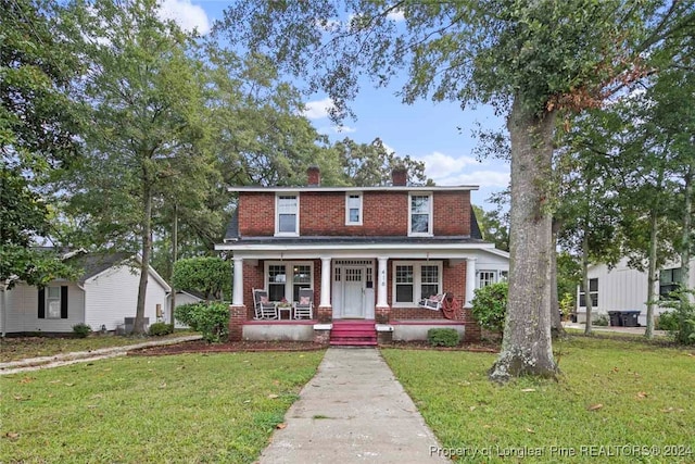 view of front of property featuring covered porch and a front yard