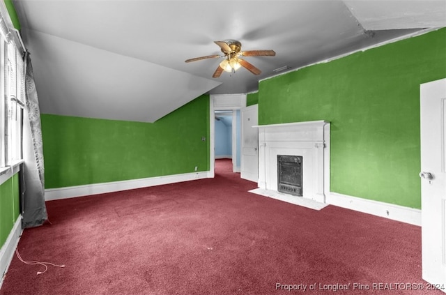 unfurnished living room featuring a premium fireplace, vaulted ceiling, ceiling fan, and carpet floors