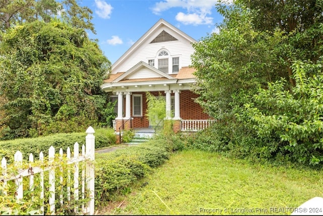 view of front facade featuring a front lawn and covered porch