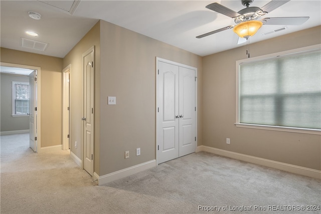 unfurnished bedroom with ceiling fan, a closet, and light colored carpet