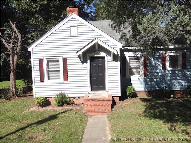 bungalow-style house featuring a front lawn