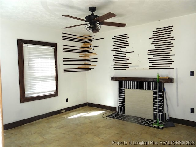 unfurnished living room with ceiling fan, a textured ceiling, and a tile fireplace