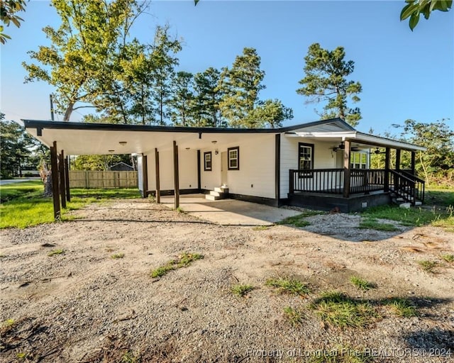 view of front of property with a carport, ceiling fan, and covered porch