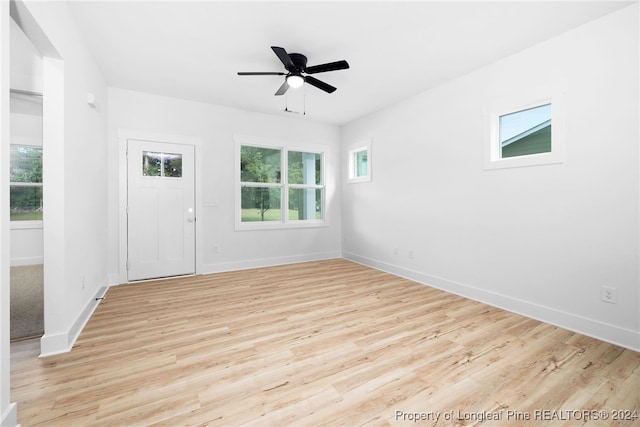 empty room with light hardwood / wood-style floors, a healthy amount of sunlight, and ceiling fan