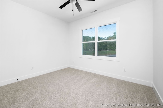 carpeted spare room featuring ceiling fan