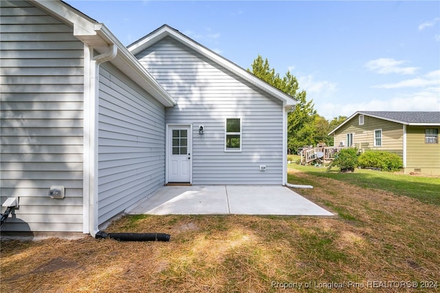 back of house featuring a patio area and a lawn