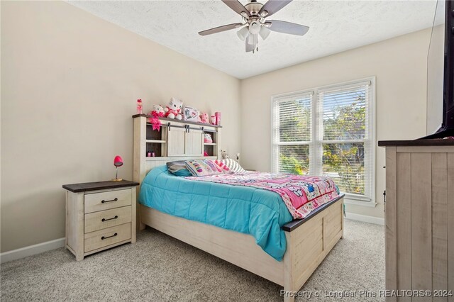 carpeted bedroom with ceiling fan and a textured ceiling