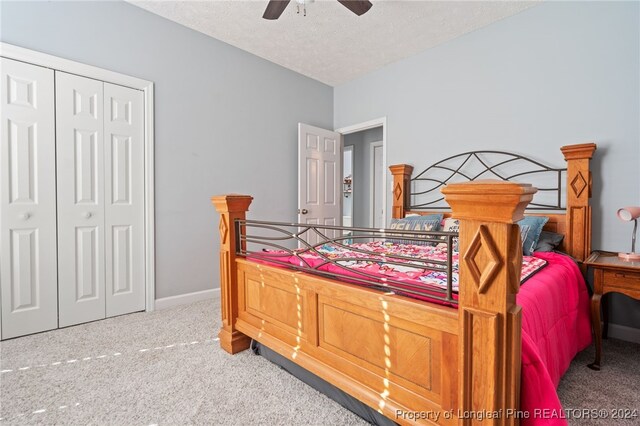 bedroom with ceiling fan, a closet, carpet floors, and a textured ceiling