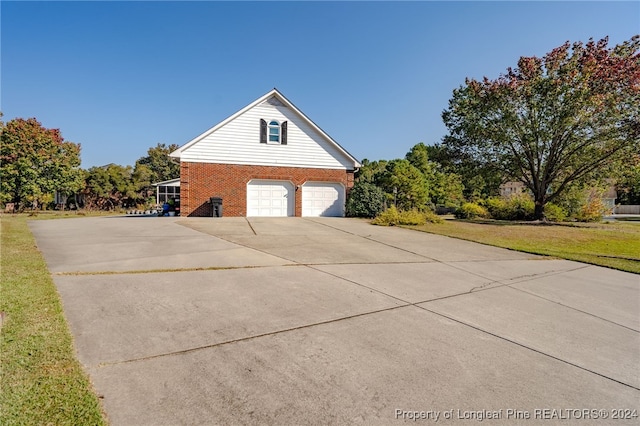 view of property exterior featuring a garage and a lawn