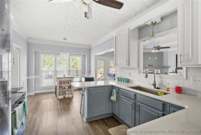 kitchen with kitchen peninsula, gray cabinetry, a textured ceiling, sink, and dark hardwood / wood-style floors