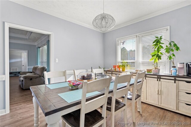 dining room with ornamental molding and hardwood / wood-style flooring